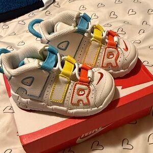 Nike Kids White Sneakers with Blue, Yellow, and Red Accents